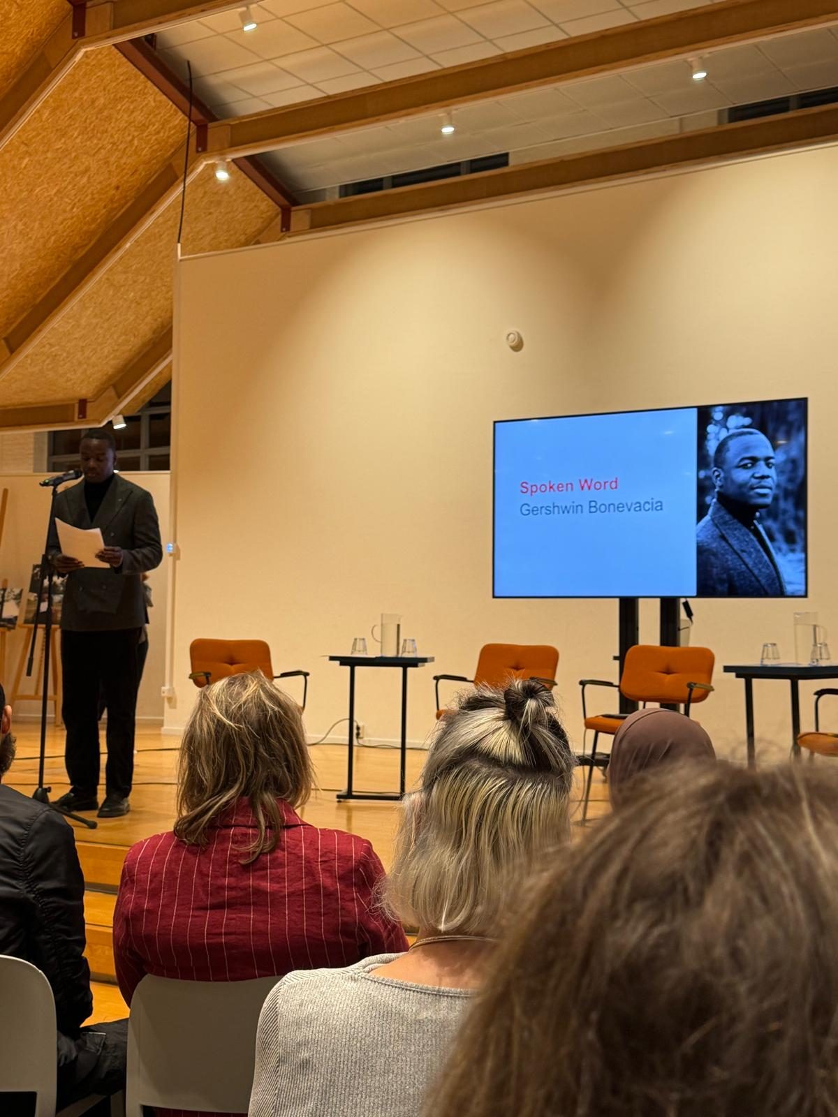 Gershwin Bonevacia draagt spoken word voor op het podium van Bieb Hoge Vucht